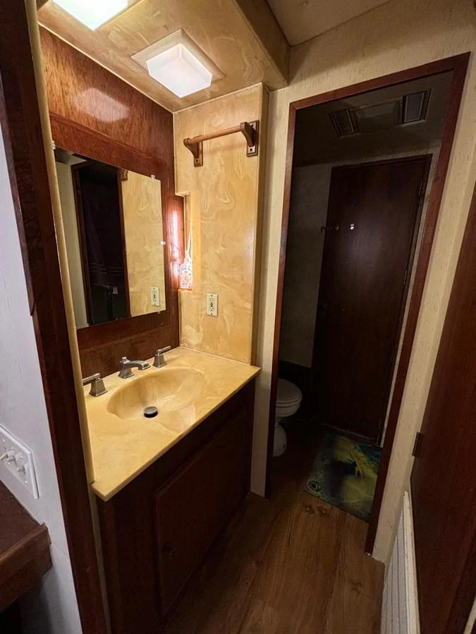 A cozy yacht bathroom with a wooden finish and a single sink vanity. aboard ADDISYN ANN Yacht for Sale