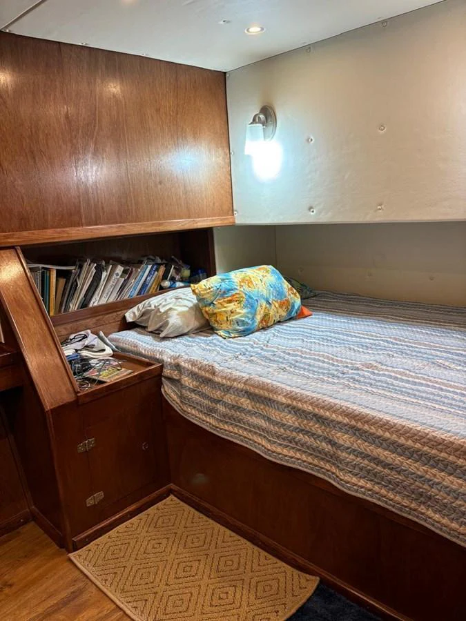 A cozy cabin with a comfortable bed and a small bookshelf, perfect for relaxation. aboard ADDISYN ANN Yacht for Sale