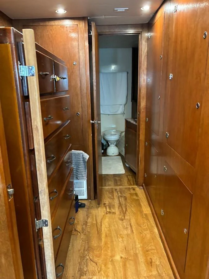 A cozy hallway with wooden cabinetry leading to a bathroom. aboard ADDISYN ANN Yacht for Sale