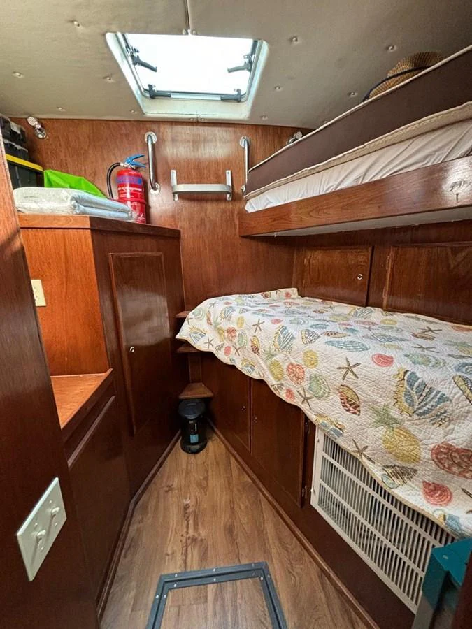 A cozy cabin featuring wooden furnishings and a bunk bed setup. aboard ADDISYN ANN Yacht for Sale