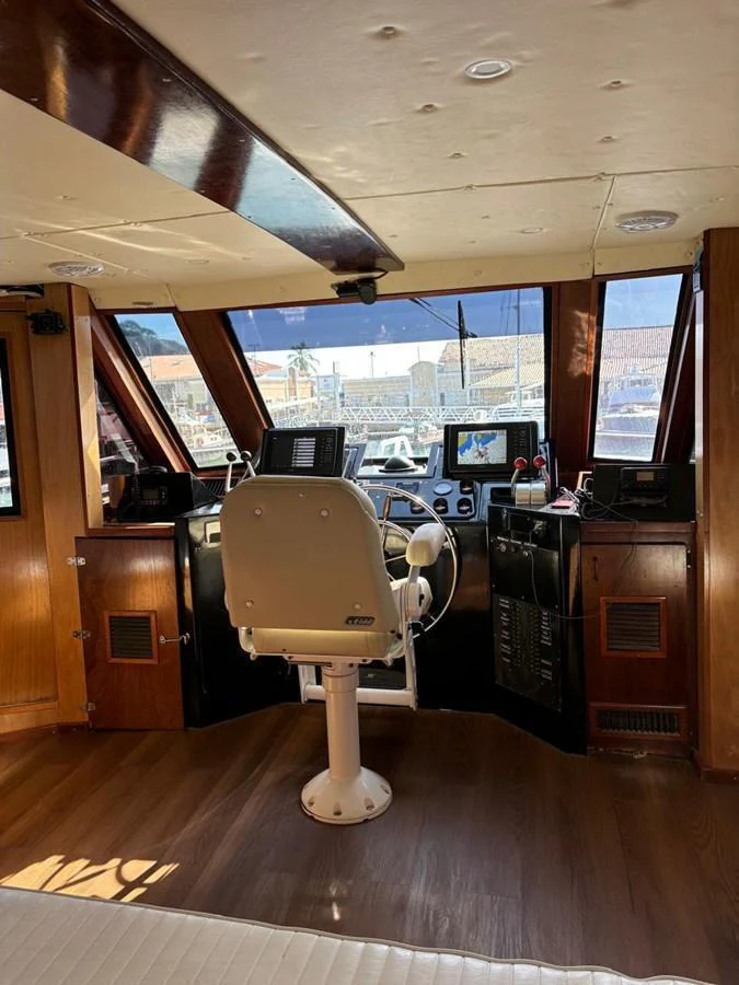 The yacht's helm features modern navigation equipment and a comfortable captain's chair. aboard ADDISYN ANN Yacht for Sale