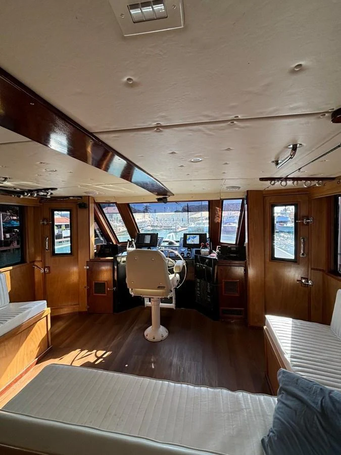 The helm area features a well-equipped control station with comfortable seating and panoramic windows. aboard ADDISYN ANN Yacht for Sale