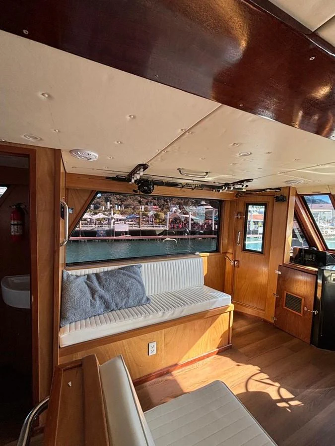 The cozy salon features comfortable seating with a view of the marina through large windows. aboard ADDISYN ANN Yacht for Sale
