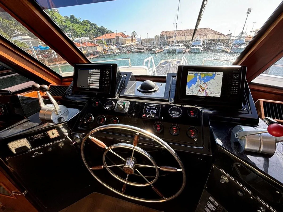 The helm station offers a commanding view with advanced navigation equipment and a classic steering wheel. aboard ADDISYN ANN Yacht for Sale
