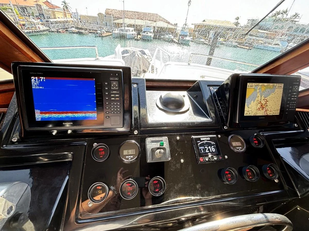 The helm station features advanced navigation and control systems with a clear view of the marina. aboard ADDISYN ANN Yacht for Sale