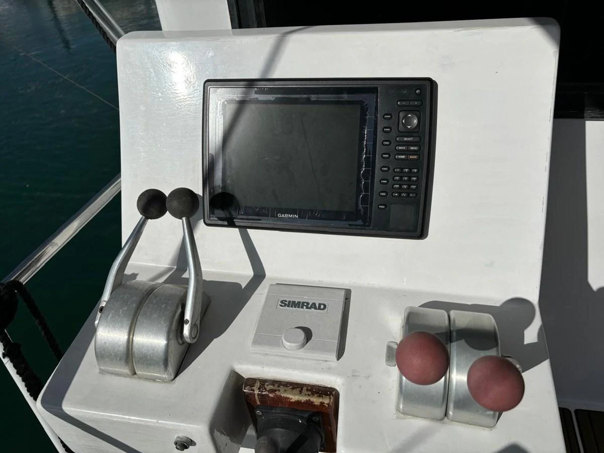 The helm features advanced navigation equipment and throttle controls. aboard ADDISYN ANN Yacht for Sale