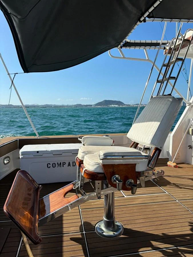The aft deck features a comfortable fishing chair with a scenic ocean backdrop. aboard ADDISYN ANN Yacht for Sale