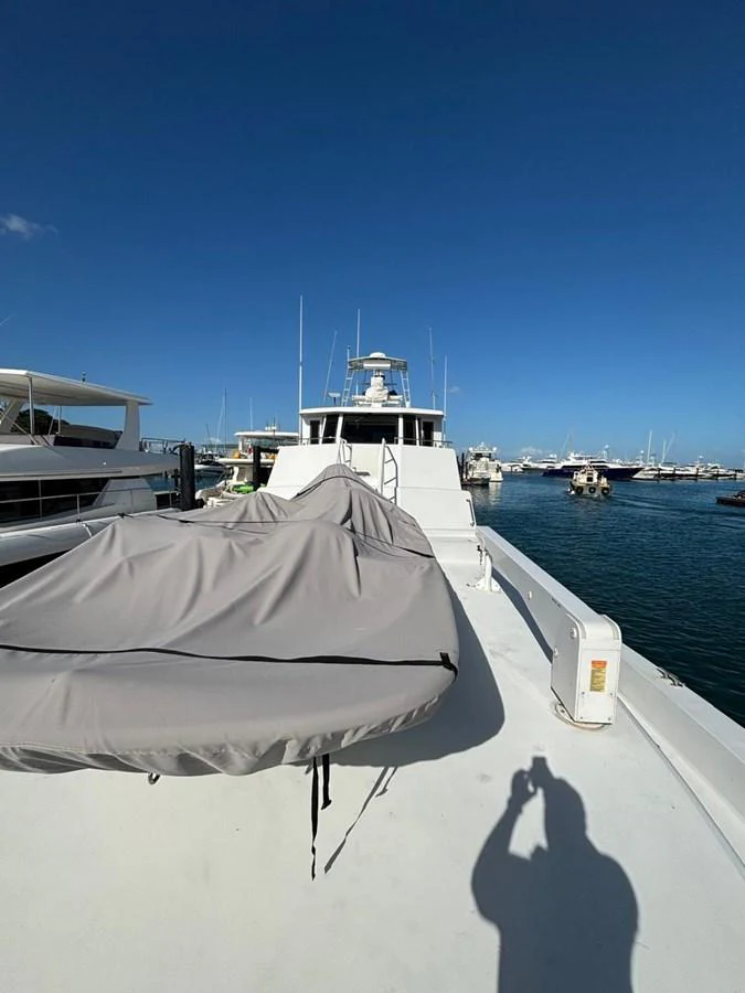 The yacht is docked at a marina, showcasing its spacious deck under a clear blue sky. aboard ADDISYN ANN Yacht for Sale