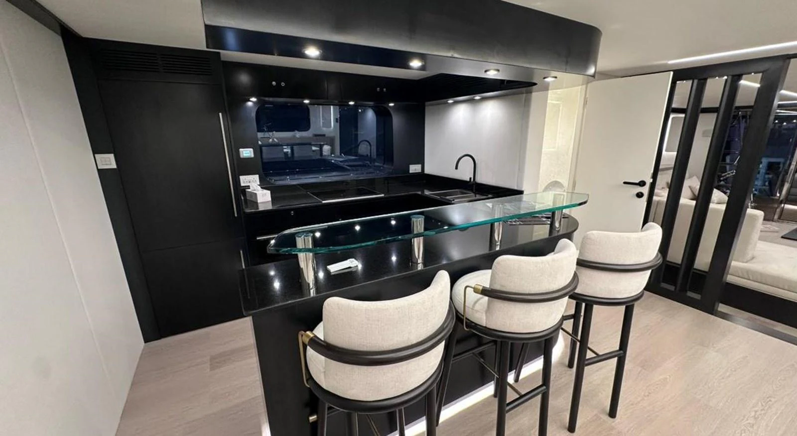 a kitchen with a bar and stools aboard XCEL 70 Yacht for Sale
