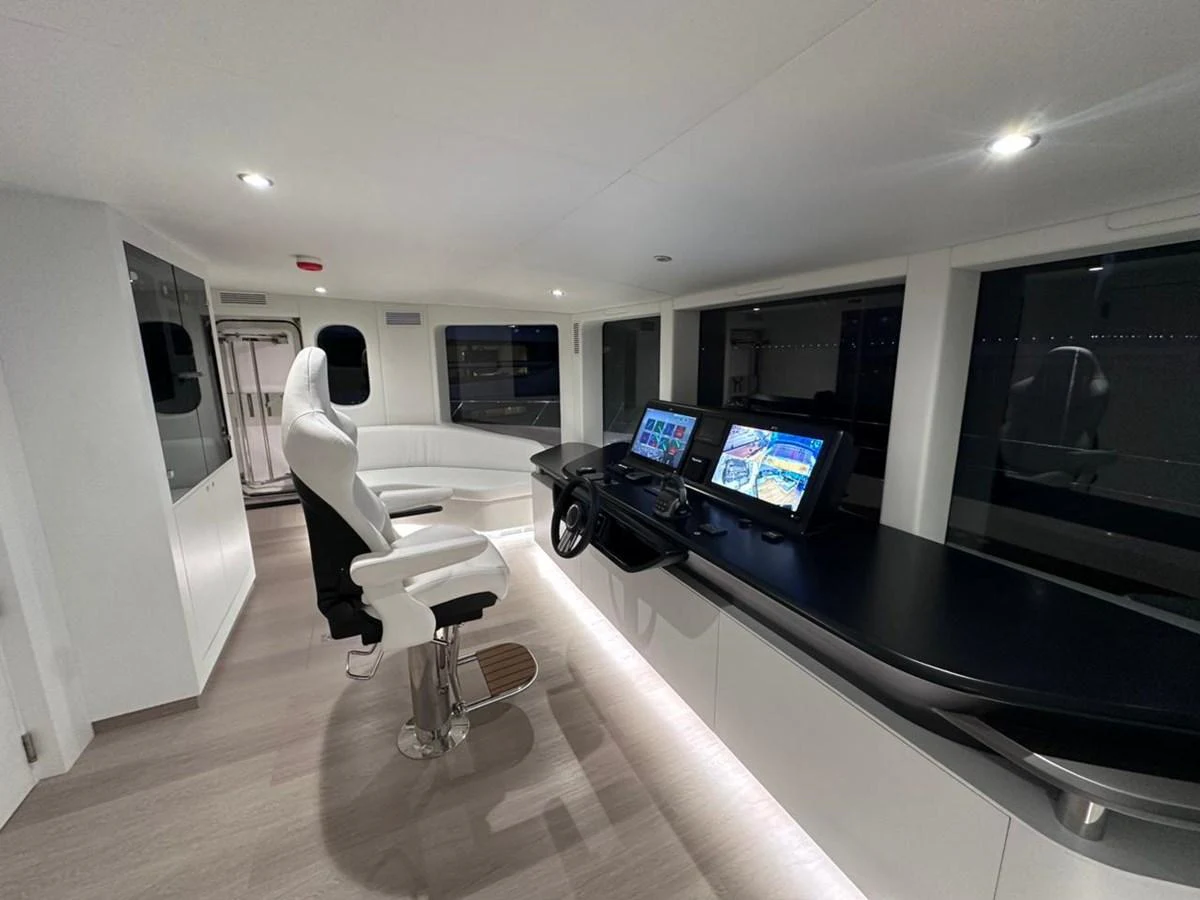 a room with a large tv and a table with chairs aboard XCEL 70 Yacht for Sale