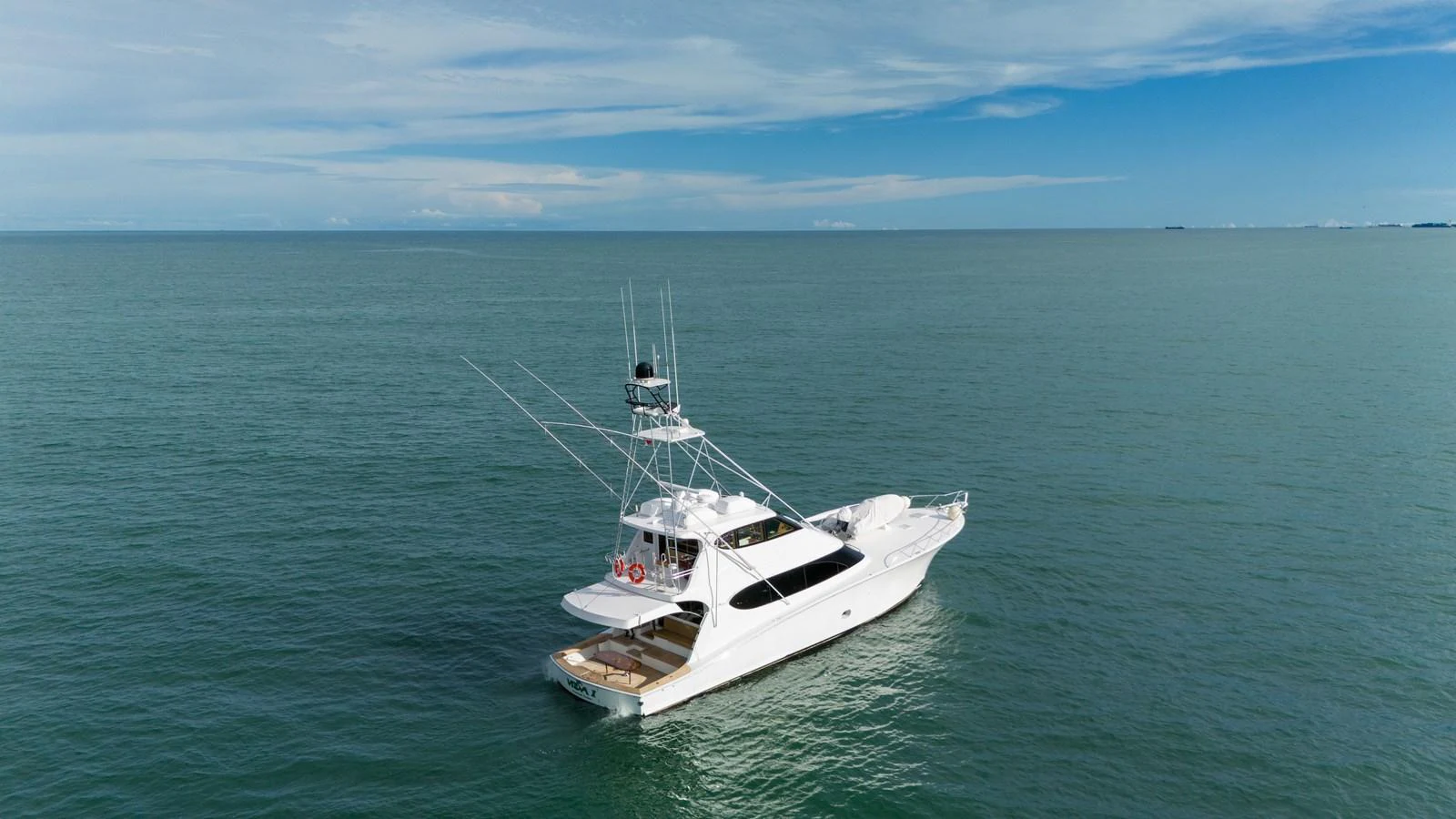 A sleek yacht cruises on calm waters under a clear sky. aboard VIDA 1 Yacht for Sale