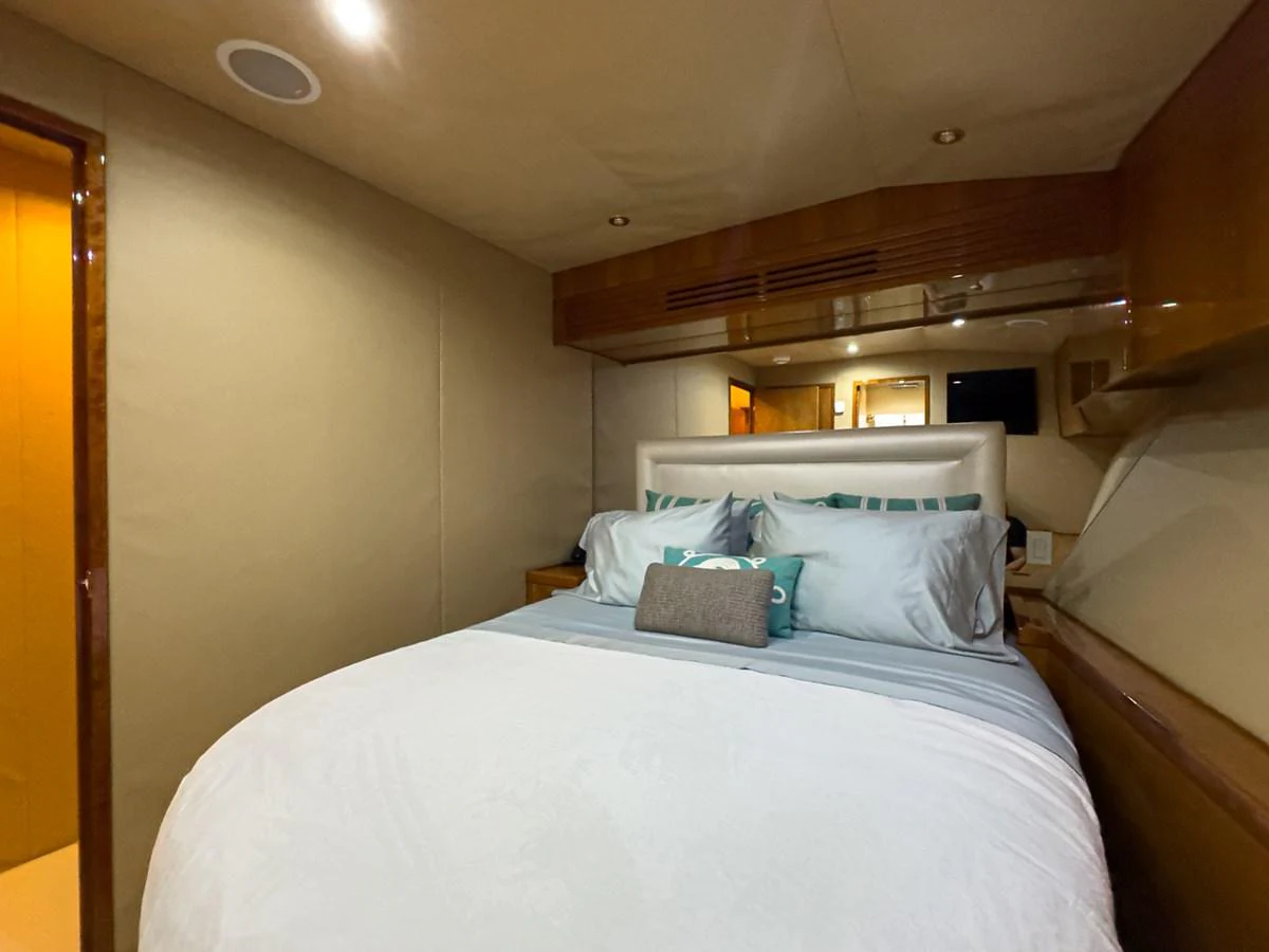 A cozy stateroom featuring a plush bed with elegant bedding and warm lighting. aboard VIDA 1 Yacht for Sale