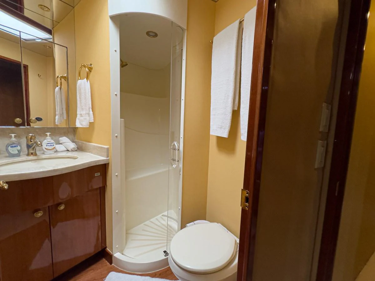 The yacht's bathroom features a compact shower, vanity, and toilet with elegant finishes. aboard VIDA 1 Yacht for Sale