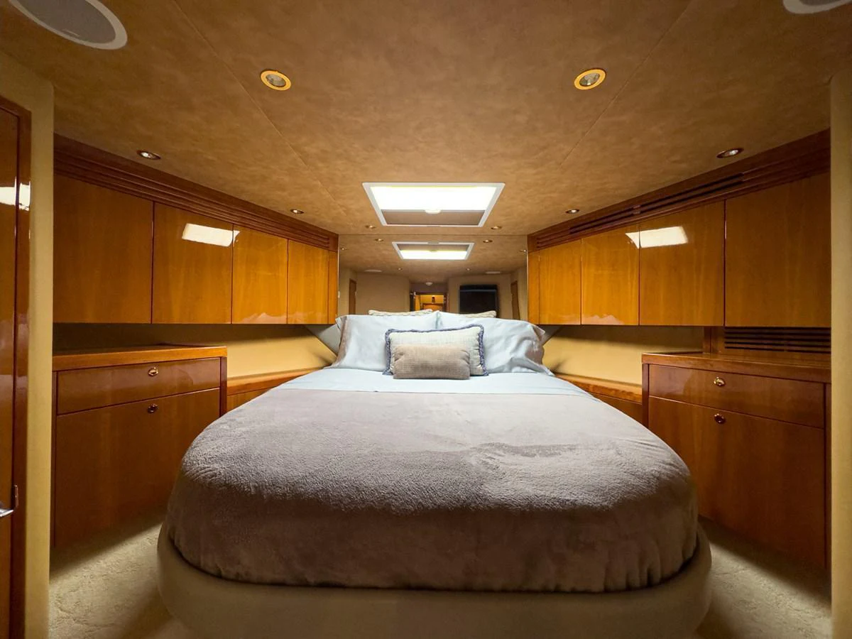 This cozy stateroom features a plush bed with ample storage and warm wood finishes. aboard VIDA 1 Yacht for Sale