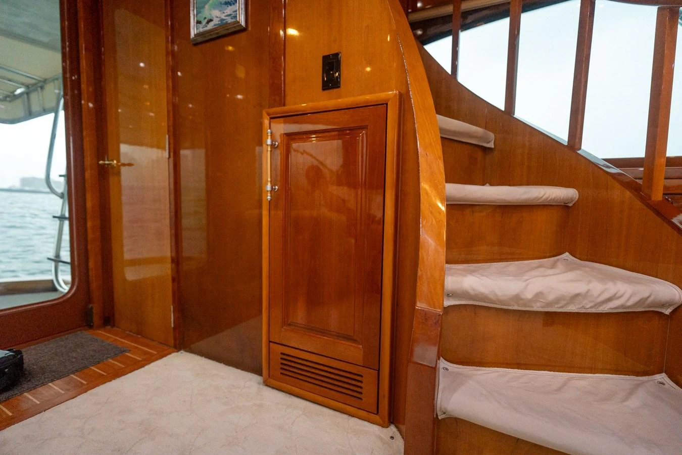 The image showcases a polished wooden staircase inside the yacht, leading to an upper deck. aboard VIDA 1 Yacht for Sale