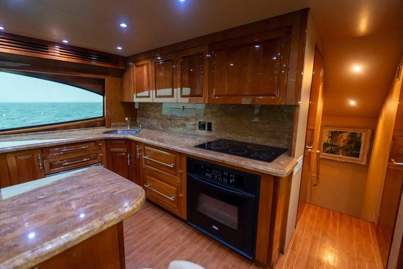 The yacht's galley features luxurious wood cabinetry and modern appliances, offering a warm and inviting space for culinary activities. aboard VIDA 1 Yacht for Sale