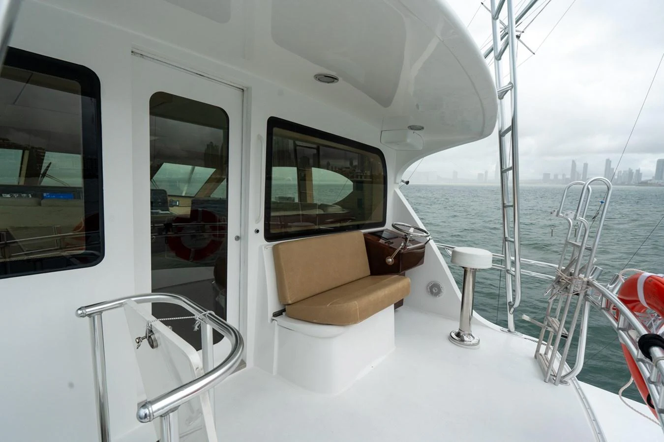 The aft deck features a comfortable seating area with a helm station, offering a perfect spot to enjoy the view. aboard VIDA 1 Yacht for Sale