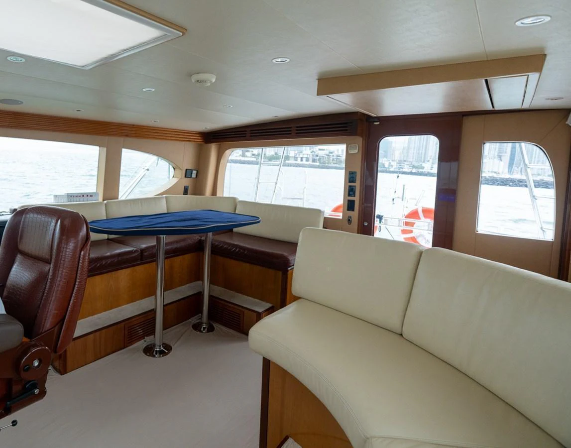 The salon features comfortable seating with large windows offering a view of the water. aboard VIDA 1 Yacht for Sale