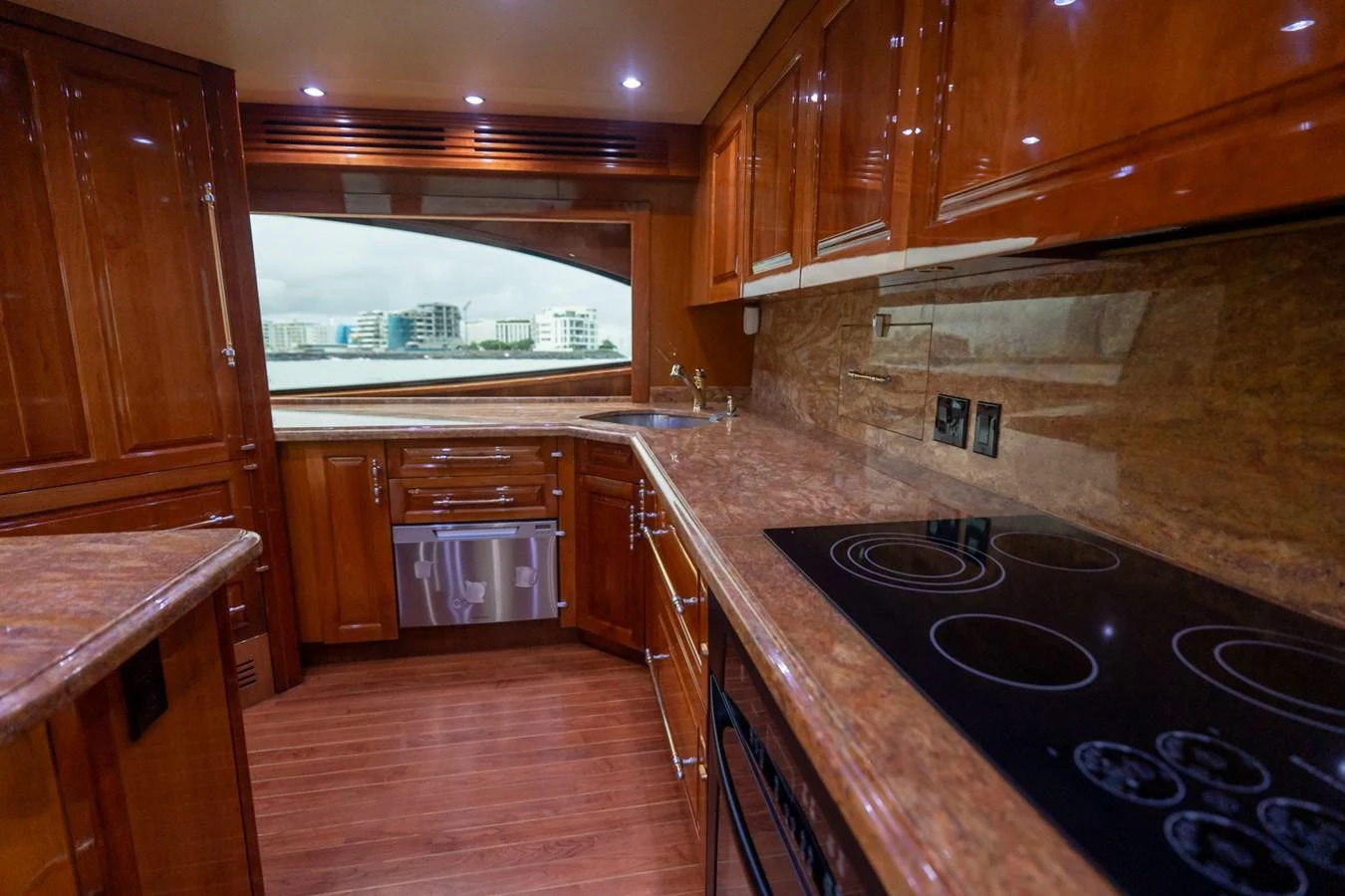 The galley features rich wooden cabinetry and modern appliances, offering a luxurious cooking space with a view. aboard VIDA 1 Yacht for Sale