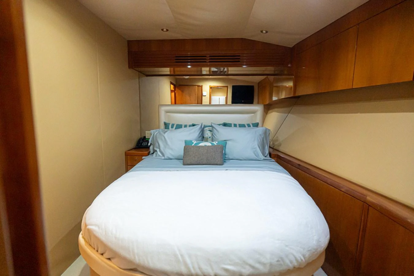 The cozy stateroom features a comfortable bed with plush pillows and elegant wood paneling. aboard VIDA 1 Yacht for Sale