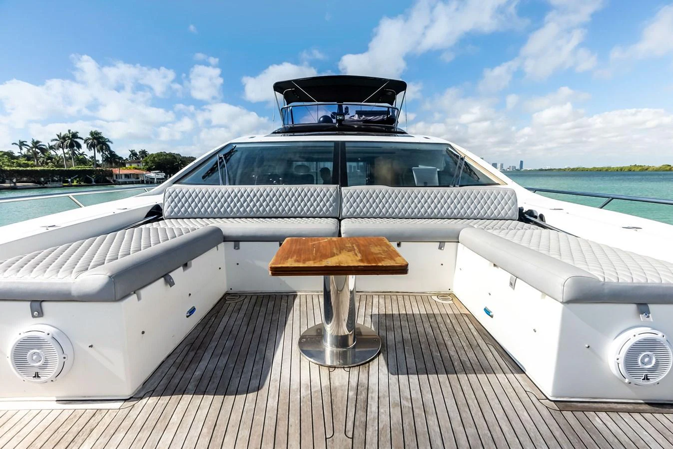 The aft deck features comfortable seating with a central wooden table, perfect for outdoor relaxation. aboard PANDA Yacht for Sale