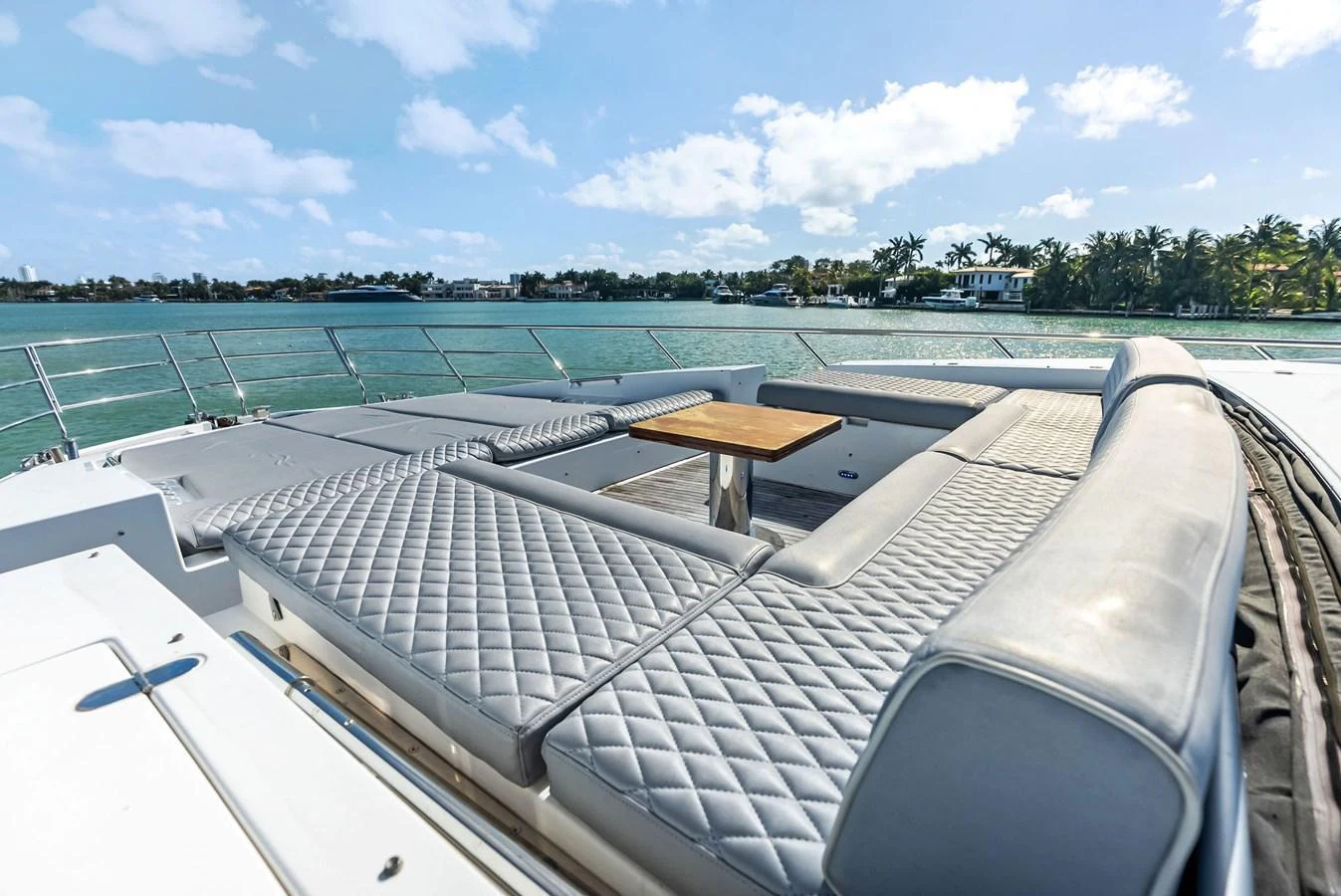 The sundeck features luxurious quilted seating with a central table, offering a perfect spot to relax and enjoy the scenic views. aboard PANDA Yacht for Sale