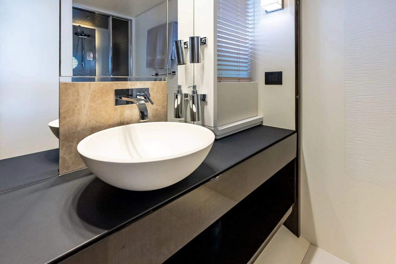 The yacht's bathroom features a sleek, modern design with a vessel sink and contemporary fixtures. aboard PANDA Yacht for Sale
