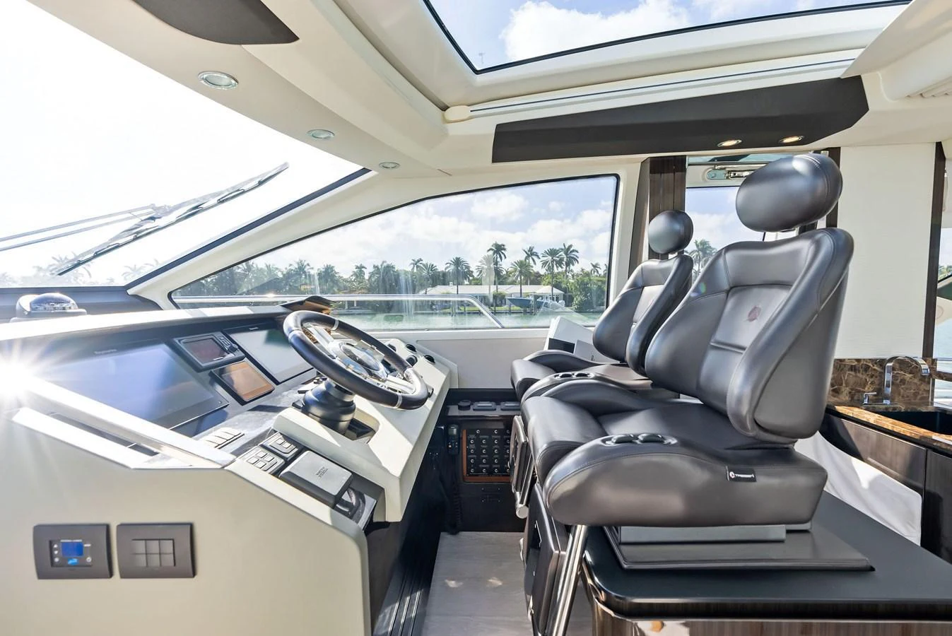 The helm station features luxurious seating and state-of-the-art navigation equipment, bathed in natural light from the expansive windows. aboard PANDA Yacht for Sale