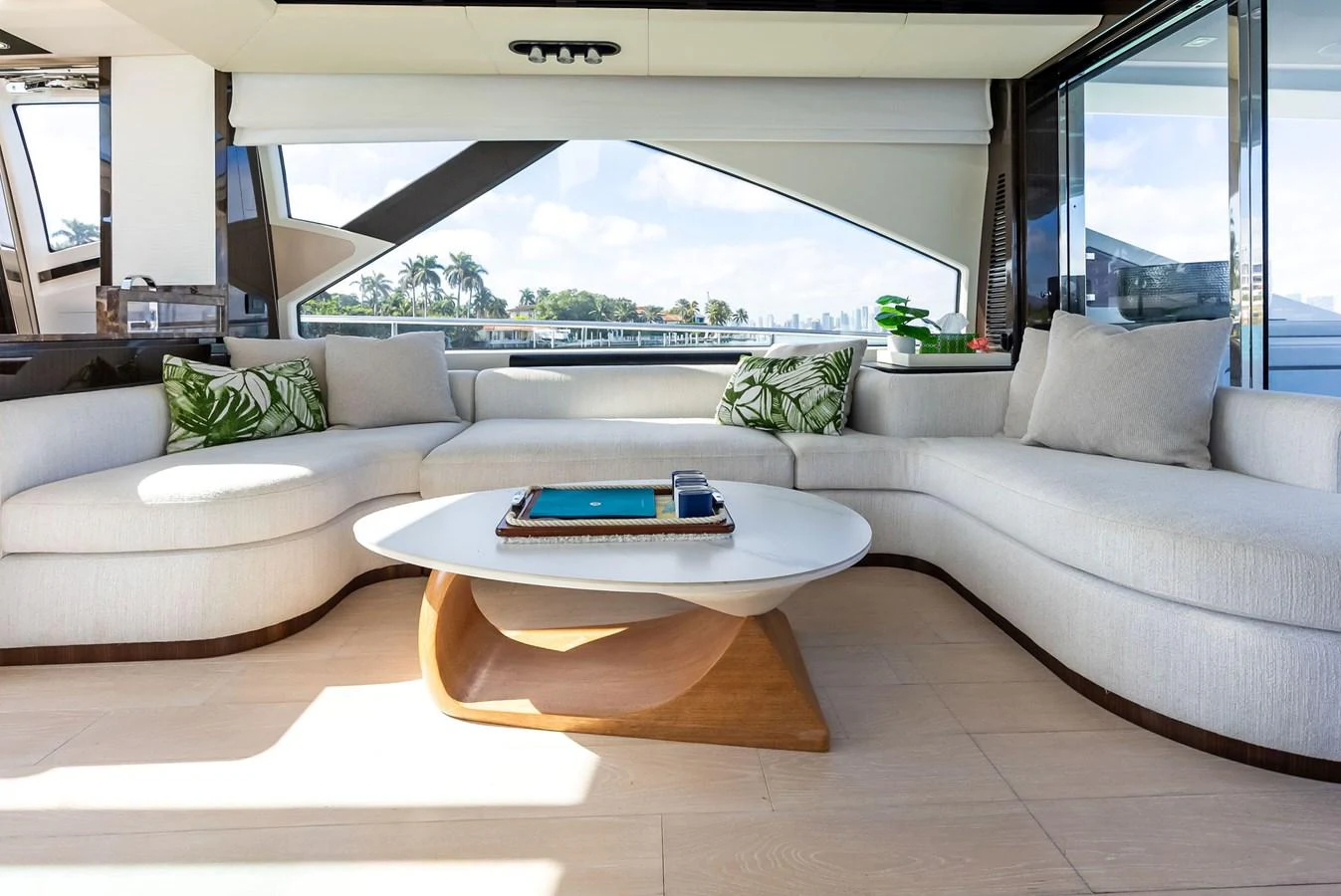 The salon features a spacious and elegant seating area with modern decor and large windows offering scenic views. aboard PANDA Yacht for Sale