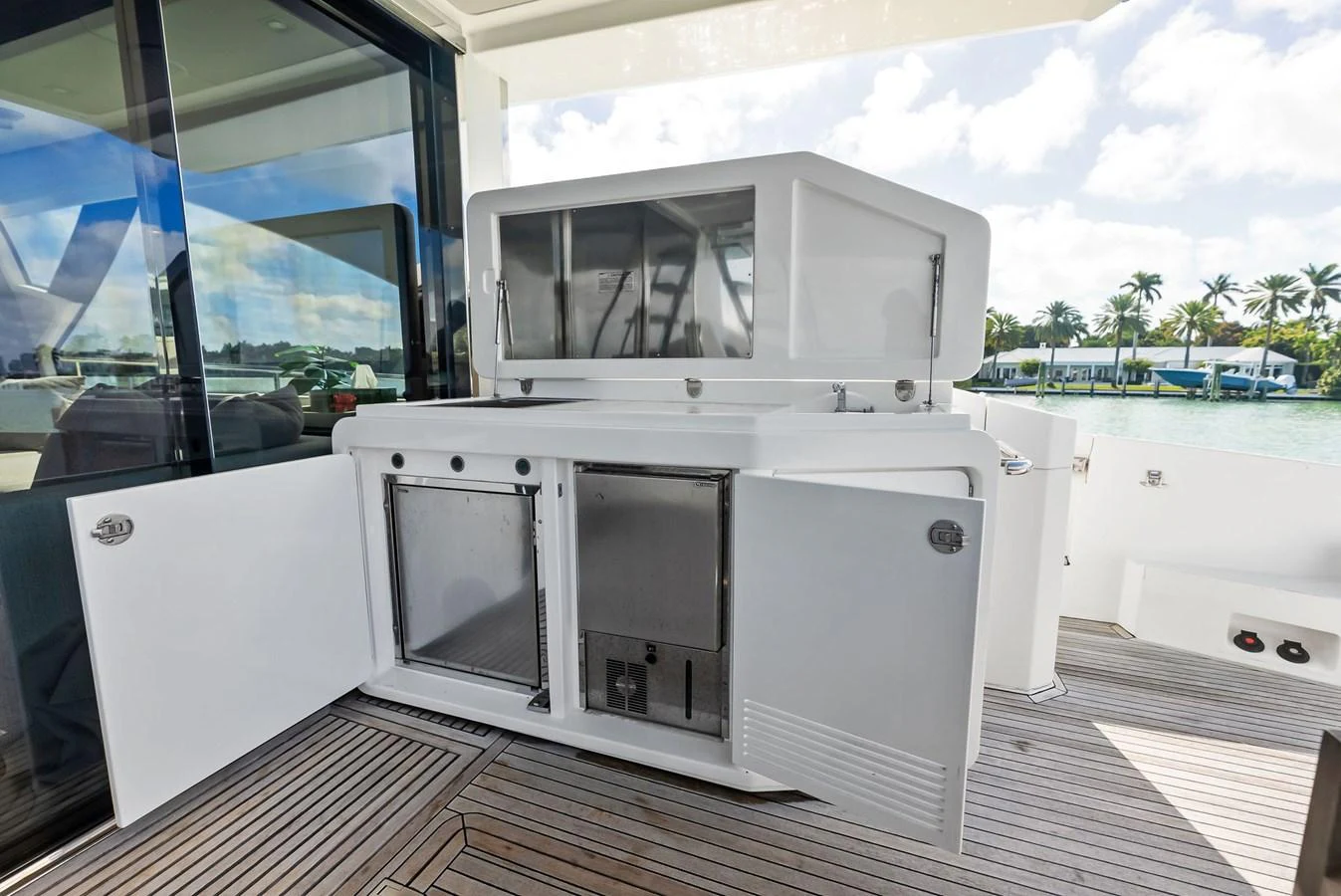 The image showcases a well-equipped outdoor galley with stainless steel appliances and ample storage space. aboard PANDA Yacht for Sale
