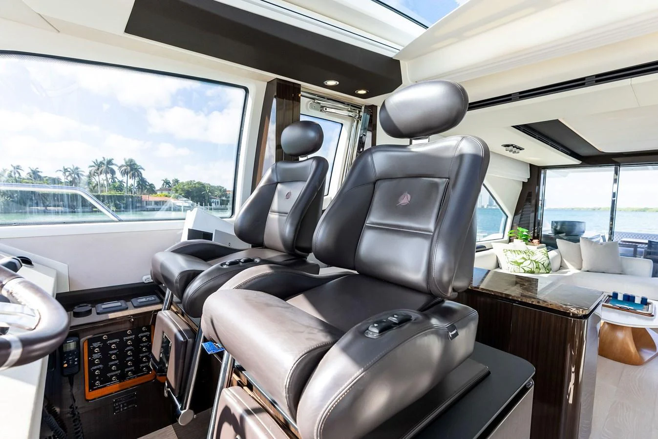 The helm area features luxurious leather captain's chairs with panoramic views through large windows. aboard PANDA Yacht for Sale
