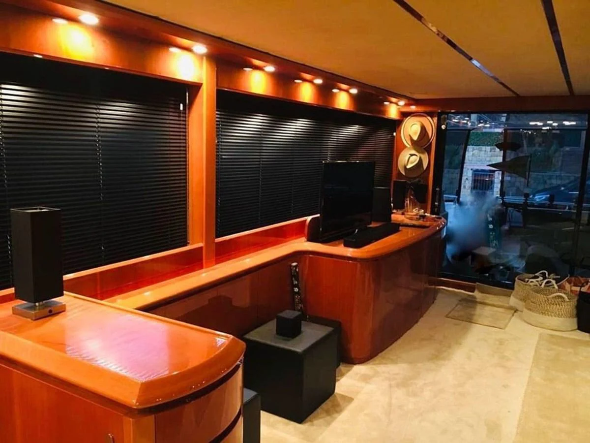 a room with a large tv and a table with a large window aboard YAIZA Yacht for Sale