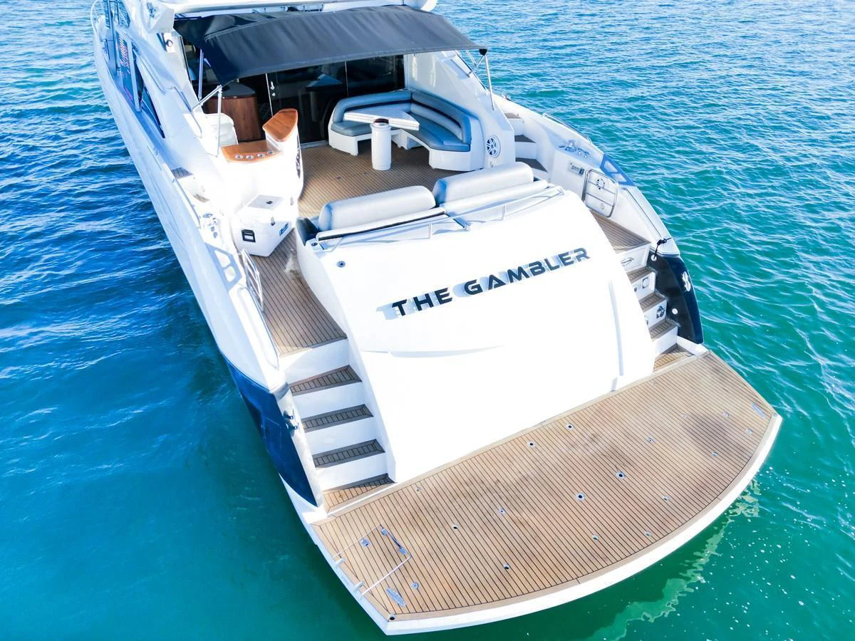 The yacht's aft deck features a spacious lounging area with comfortable seating and easy access to the water. aboard THE GAMBLER Yacht for Sale