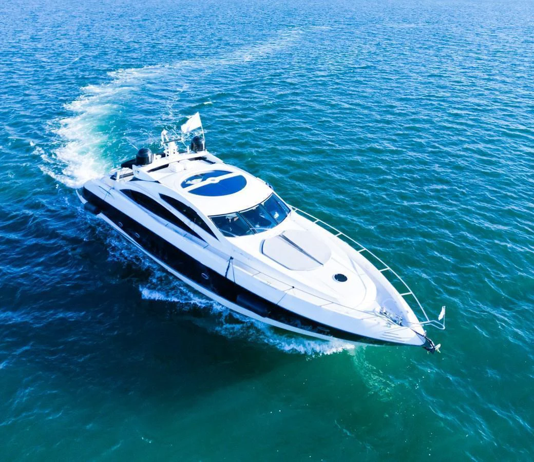 A sleek and modern yacht glides effortlessly through the clear blue waters. aboard THE GAMBLER Yacht for Sale