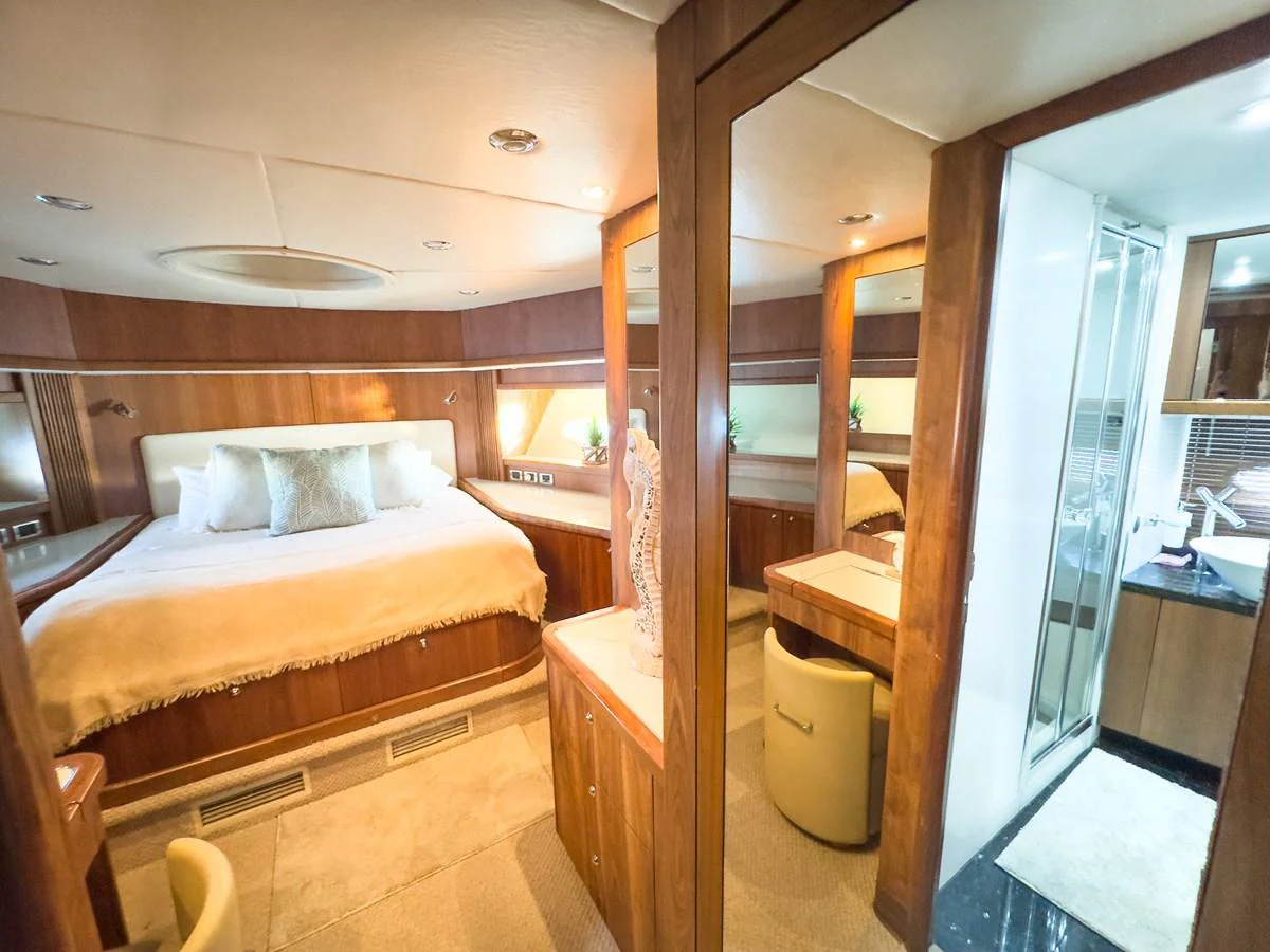 The master stateroom features a luxurious bed, ample storage, and elegant wood finishes. aboard THE GAMBLER Yacht for Sale
