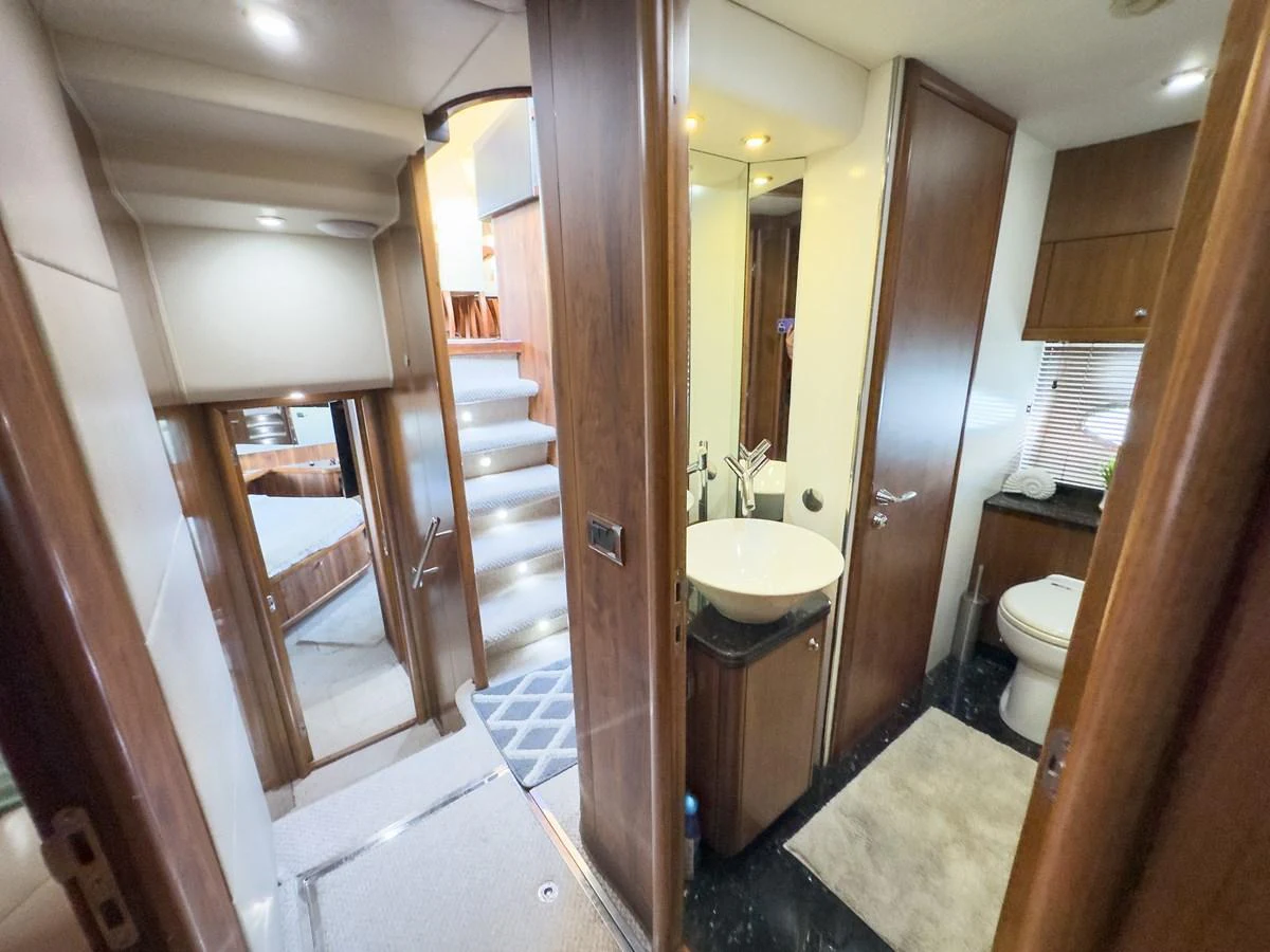The yacht's interior features a hallway with access to a bathroom and stairs leading to different levels. aboard THE GAMBLER Yacht for Sale