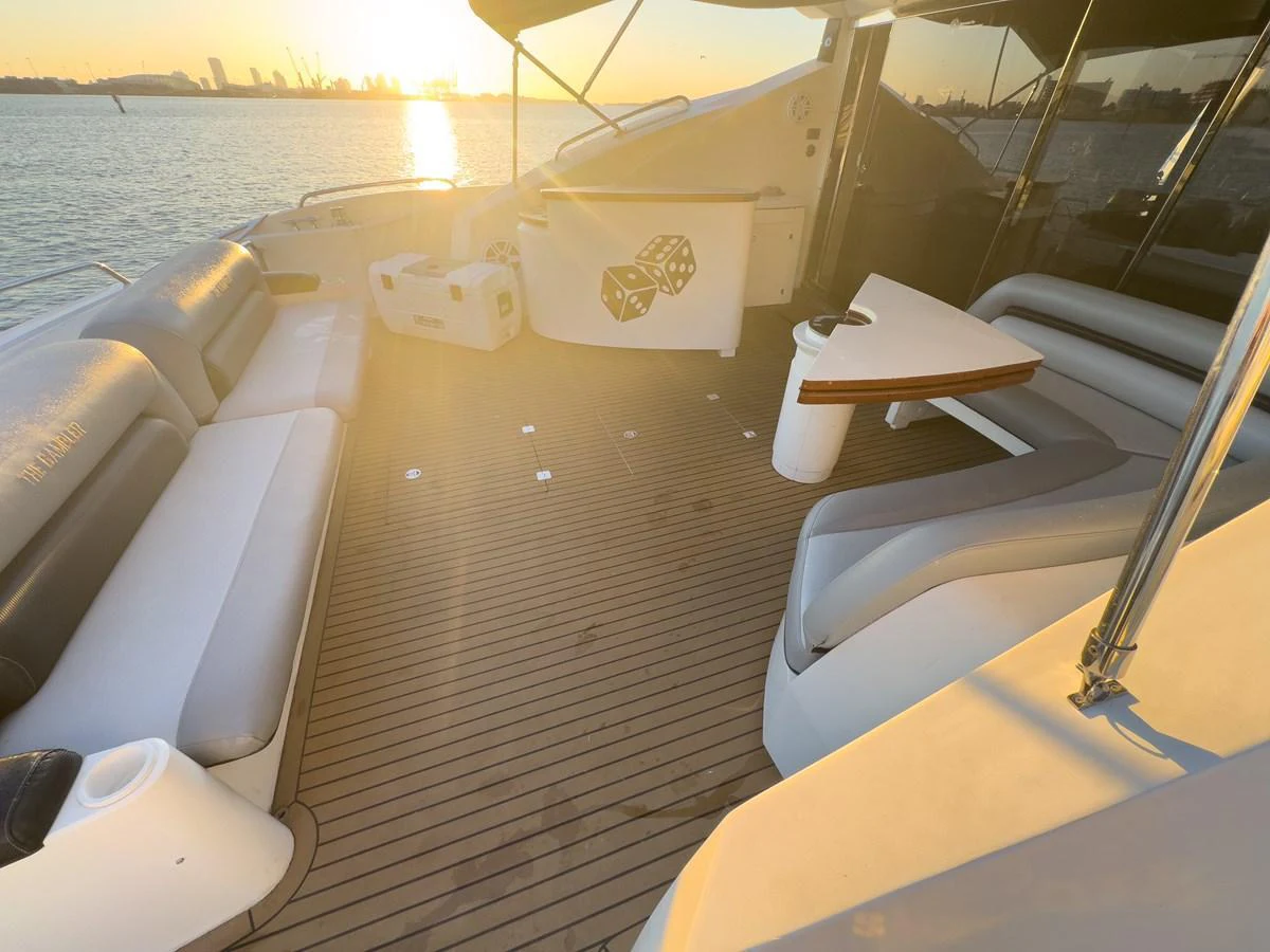 The aft deck features comfortable seating and a table, perfect for enjoying the sunset over the water. aboard THE GAMBLER Yacht for Sale