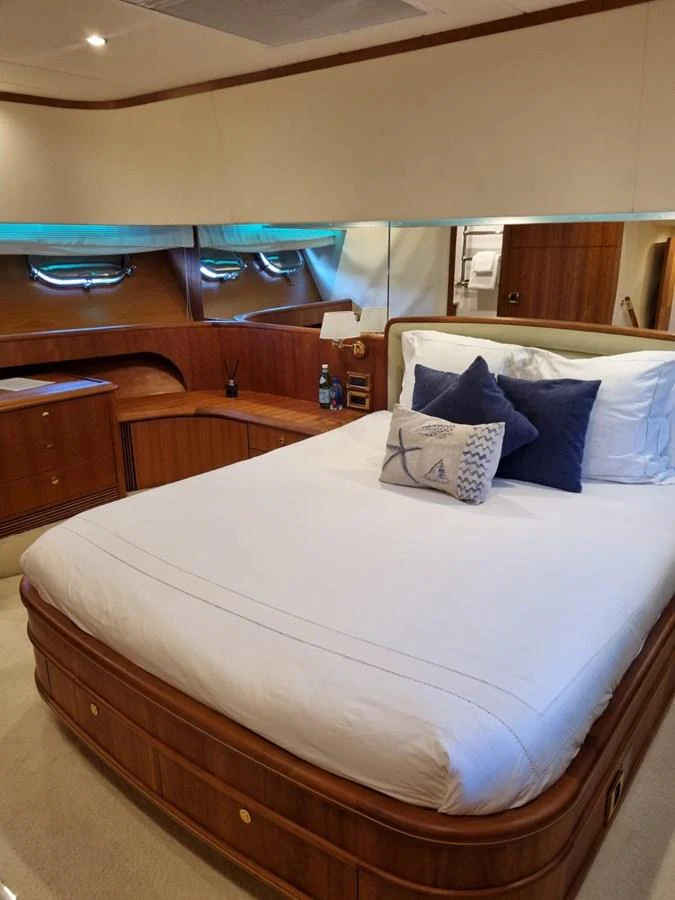 a bed with a white bed spread aboard LADY AMANDA Yacht for Sale