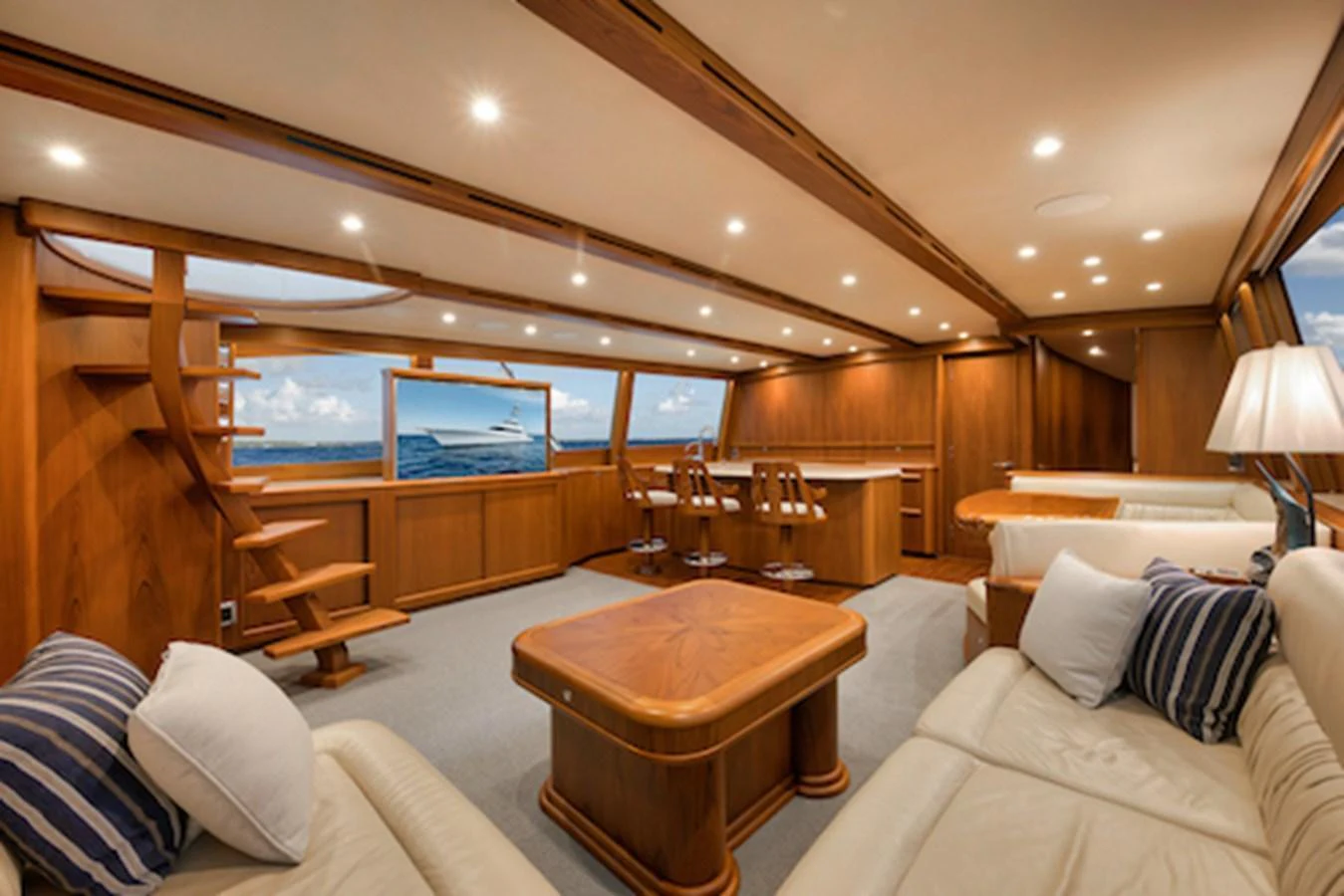 The salon features luxurious seating, a wooden table, and ample natural light through large windows. aboard BREE Yacht for Sale