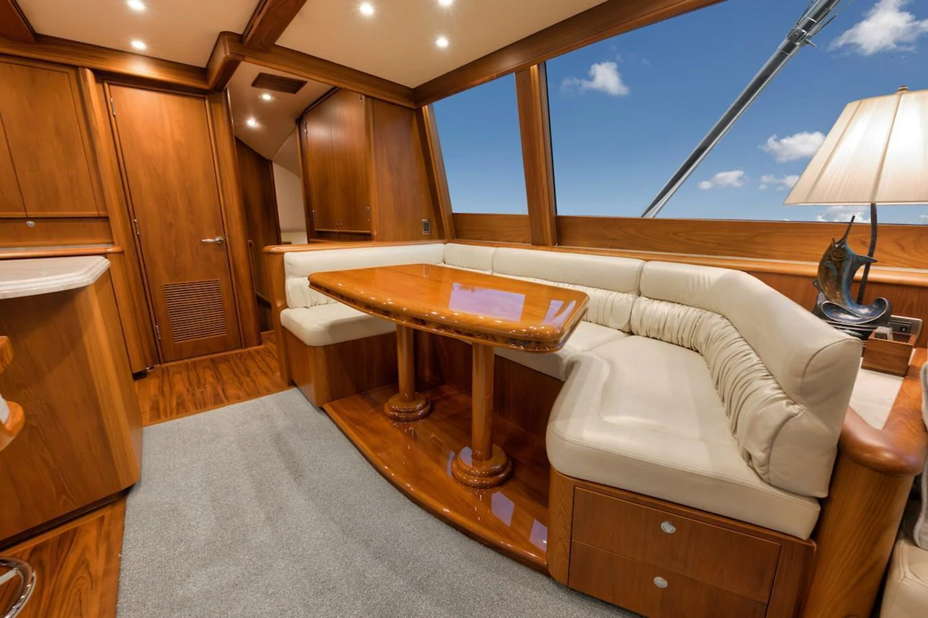 The salon features a cozy seating area with a polished wooden table and ample natural light. aboard BREE Yacht for Sale