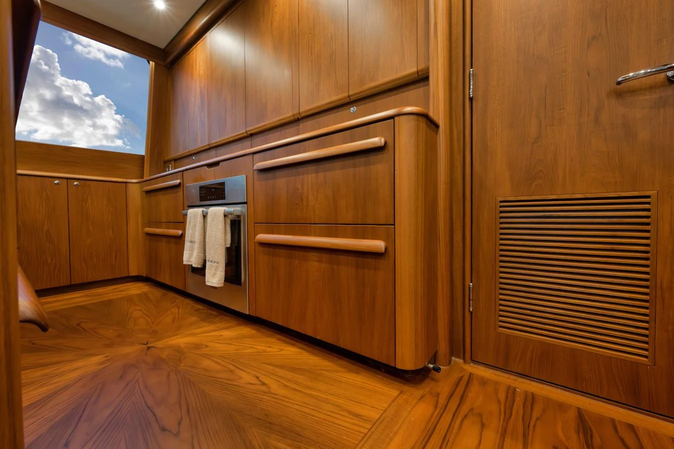 The yacht's interior features rich wood paneling and modern cabinetry, creating a warm and inviting atmosphere. aboard BREE Yacht for Sale