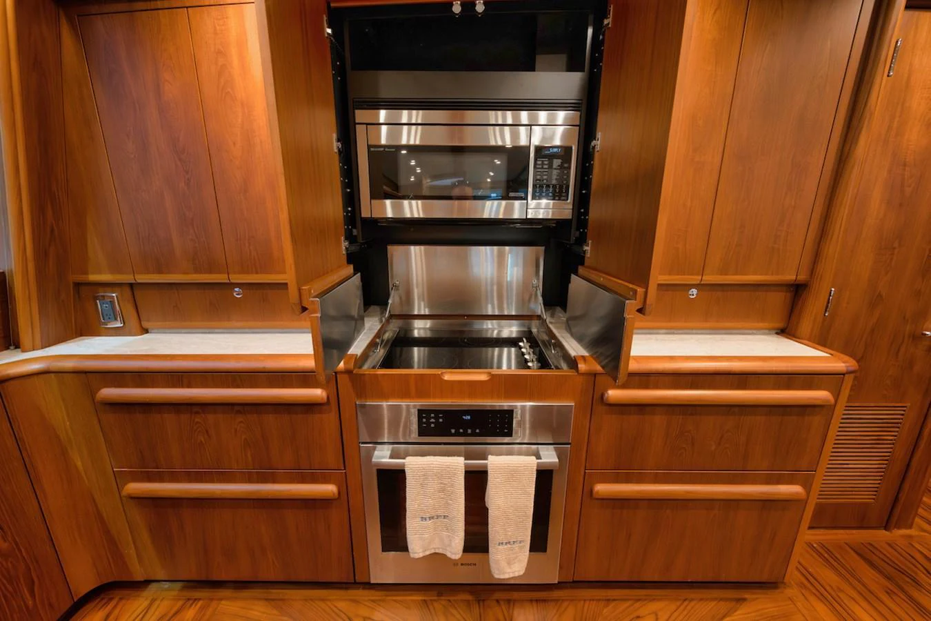 The galley features sleek wooden cabinetry and modern stainless steel appliances. aboard BREE Yacht for Sale