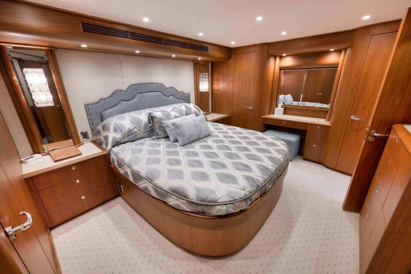 The master stateroom features a luxurious bed with elegant bedding and ample wooden cabinetry. aboard BREE Yacht for Sale