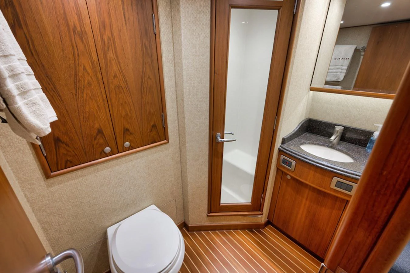 The yacht's bathroom features elegant wood cabinetry, a modern sink, and a glass-enclosed shower. aboard BREE Yacht for Sale