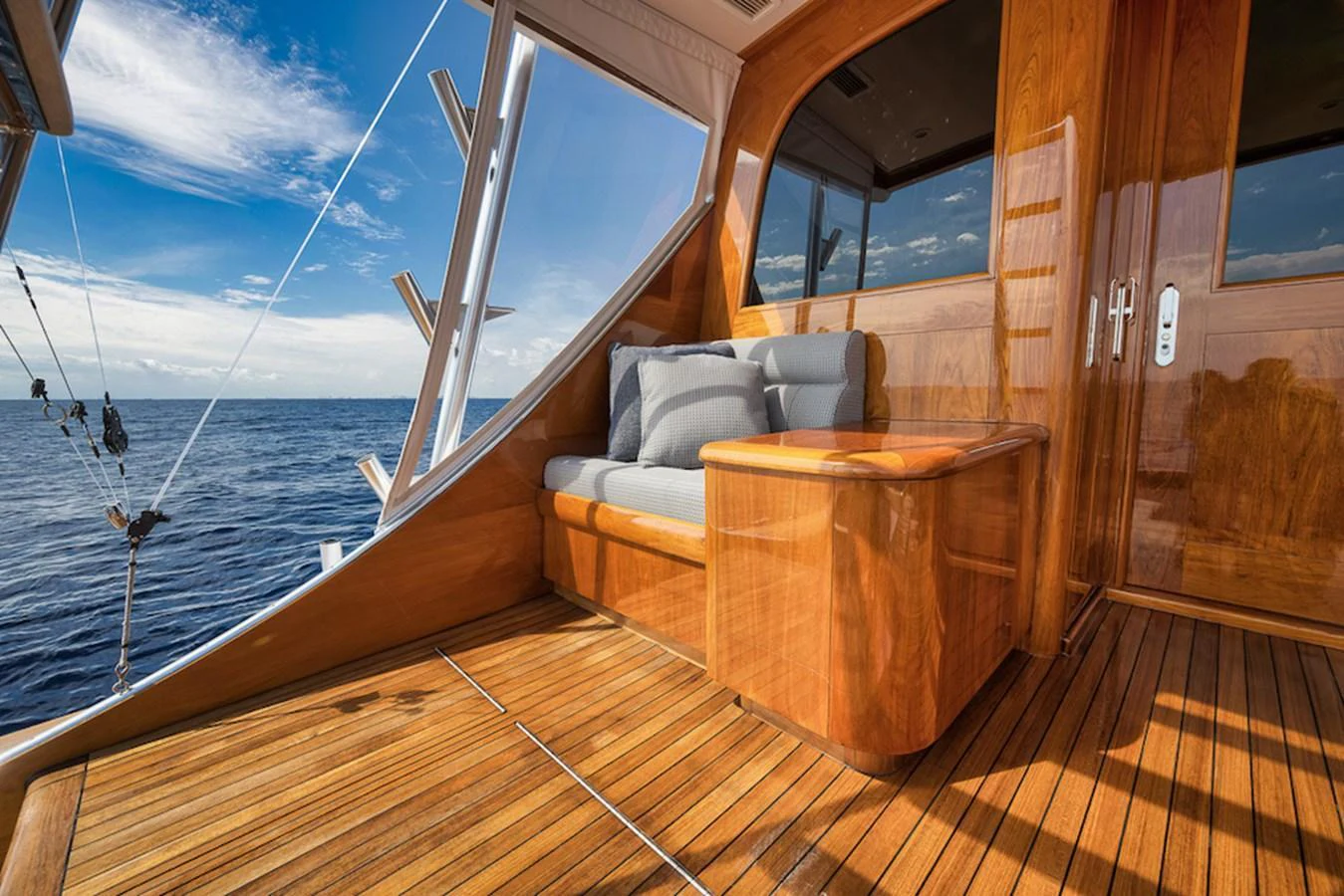 The aft deck features a comfortable seating area with a polished wooden table, offering stunning ocean views. aboard BREE Yacht for Sale