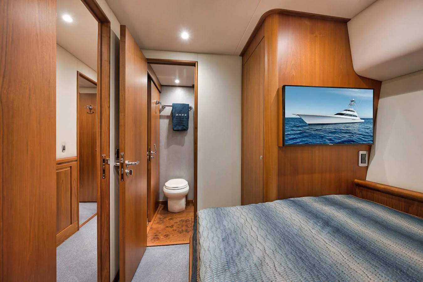 A cozy stateroom featuring a bed, wooden cabinetry, and an en-suite bathroom. aboard BREE Yacht for Sale