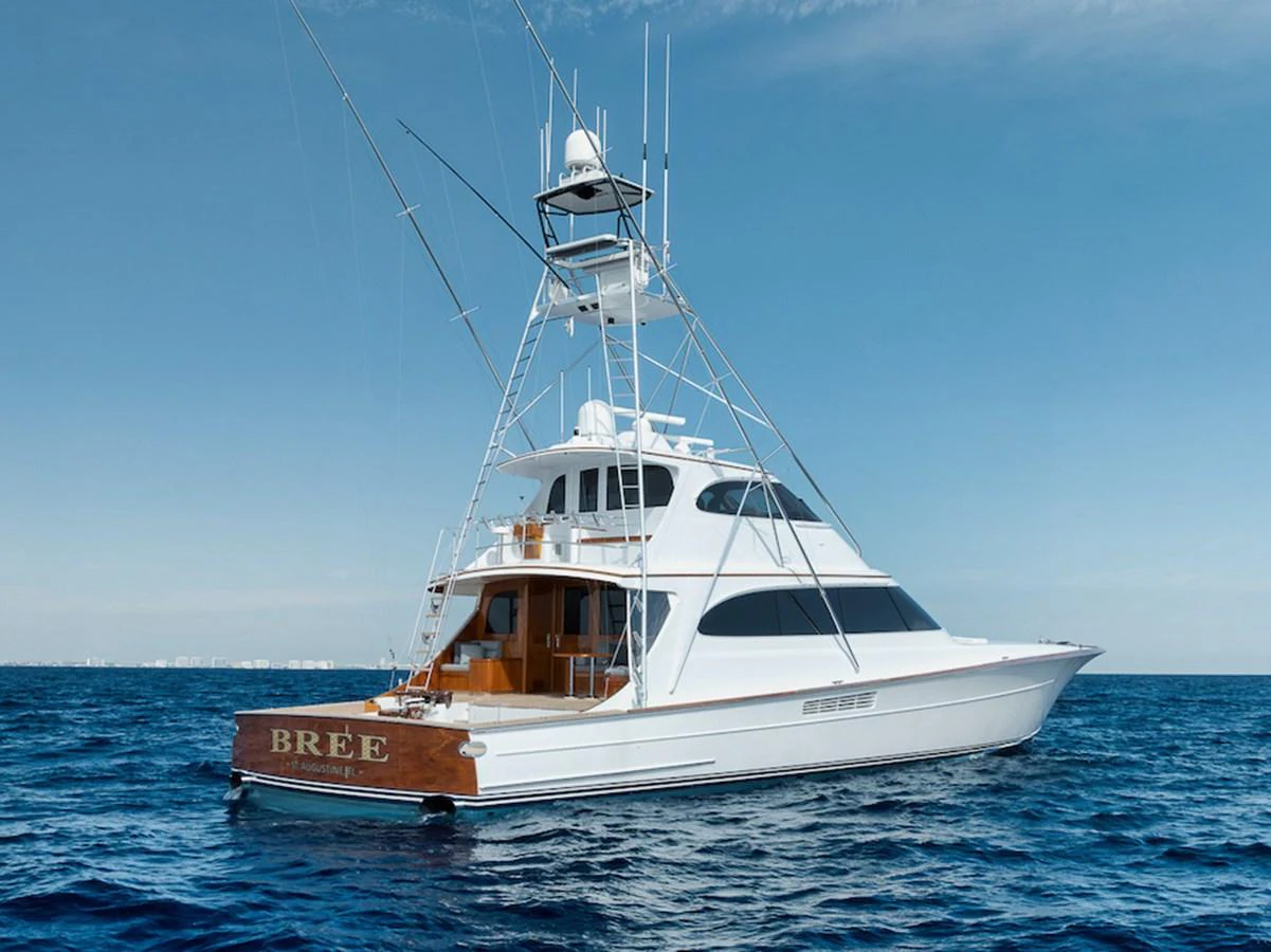 A sleek white yacht cruises gracefully on the open sea under a clear blue sky. aboard BREE Yacht for Sale
