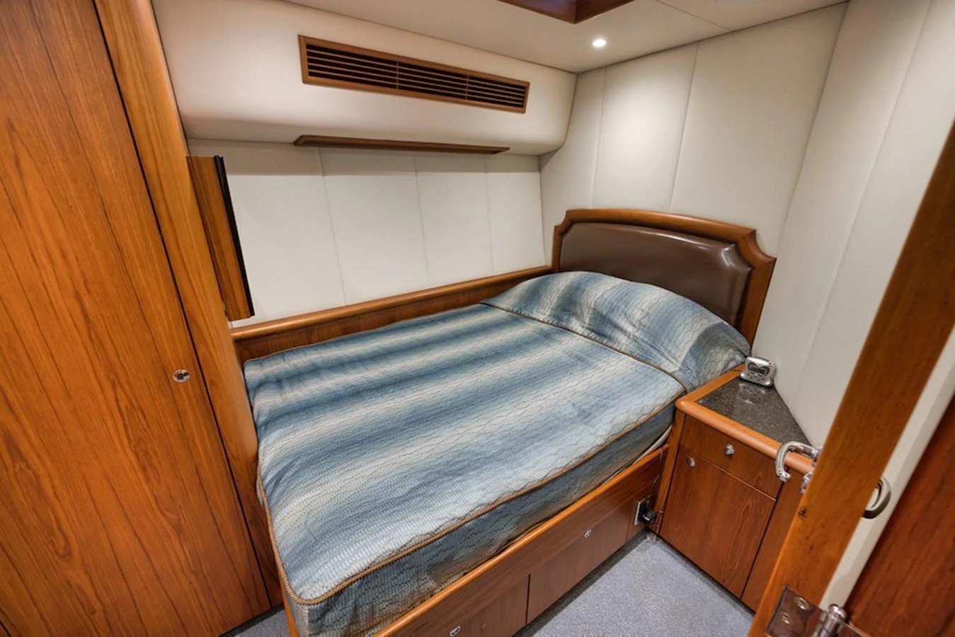A cozy stateroom featuring a comfortable bed with wooden cabinetry and soft lighting. aboard BREE Yacht for Sale