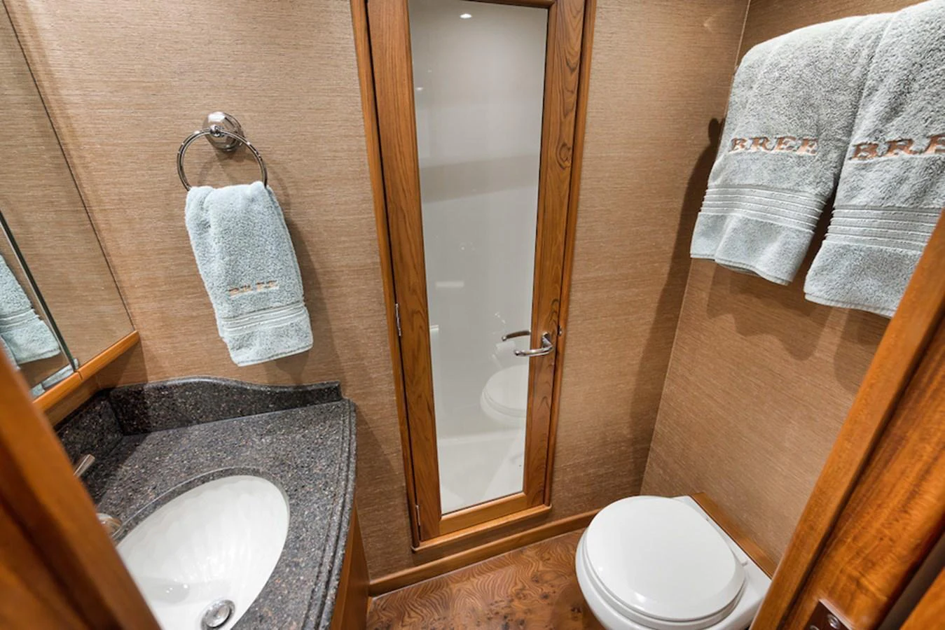 A well-appointed yacht bathroom featuring a sleek sink, a toilet, and neatly arranged towels. aboard BREE Yacht for Sale