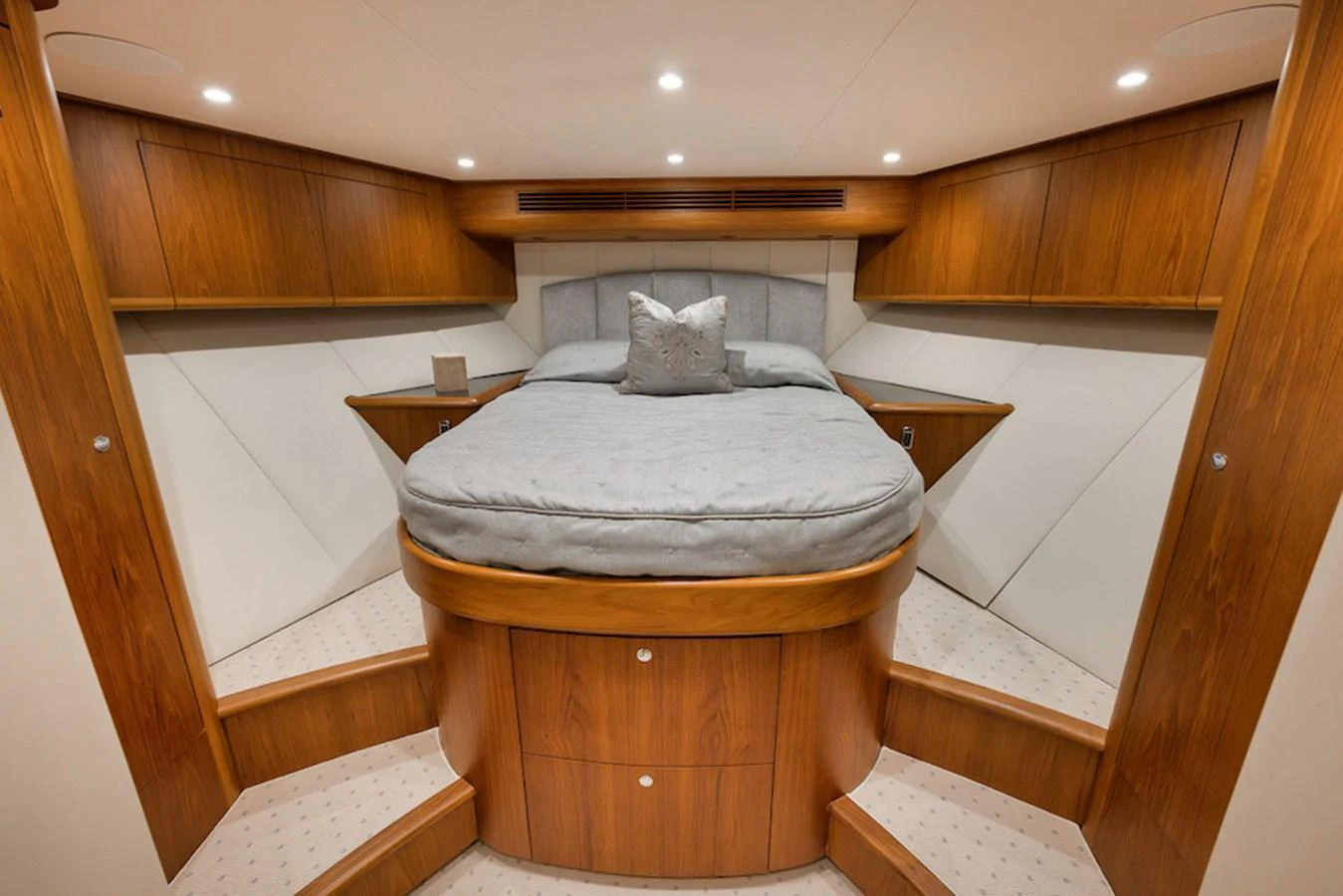 The stateroom features a luxurious bed with elegant wooden cabinetry and soft lighting. aboard BREE Yacht for Sale